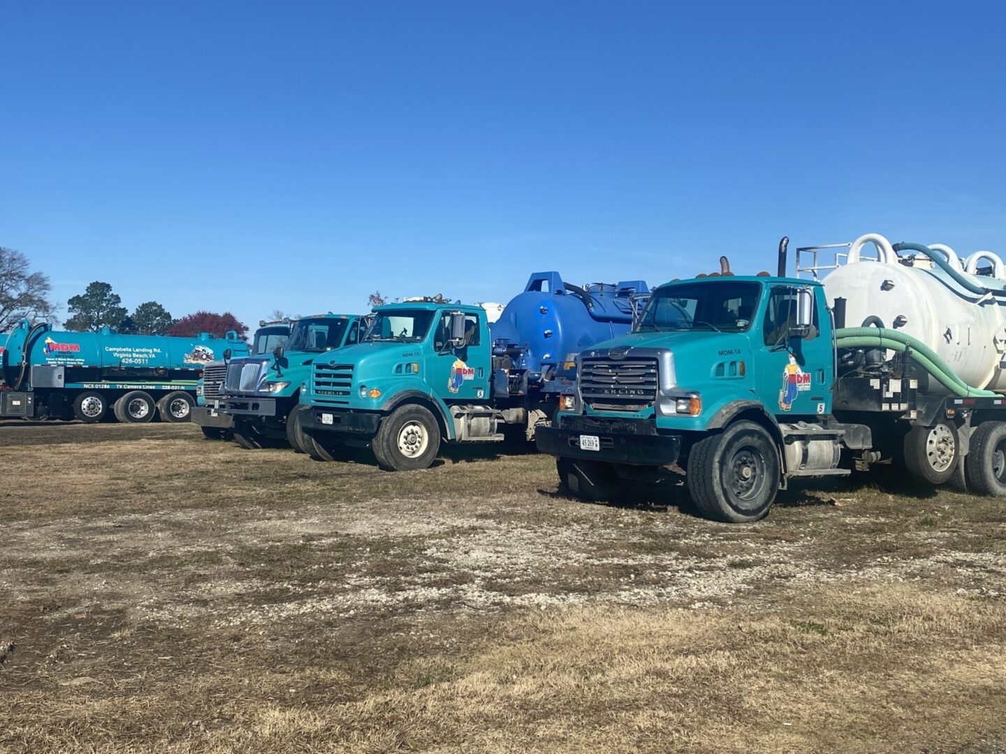 A group of trucks parked in the dirt.