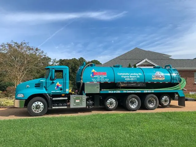 A blue truck is parked in the grass.