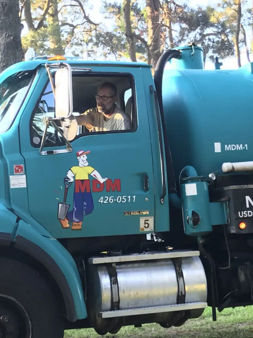 A man sitting in the drivers seat of a truck.