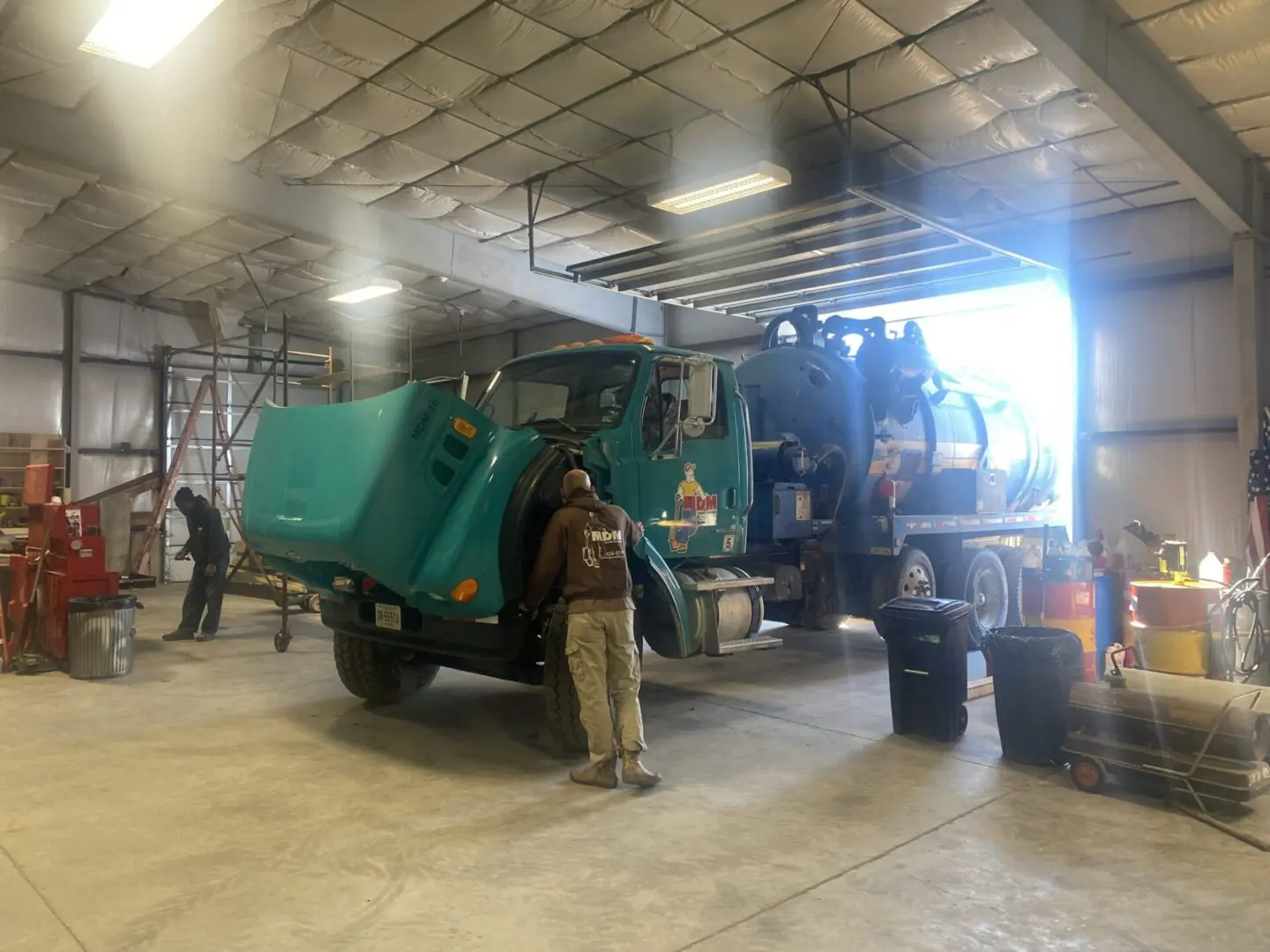 A man standing next to a truck in a garage.