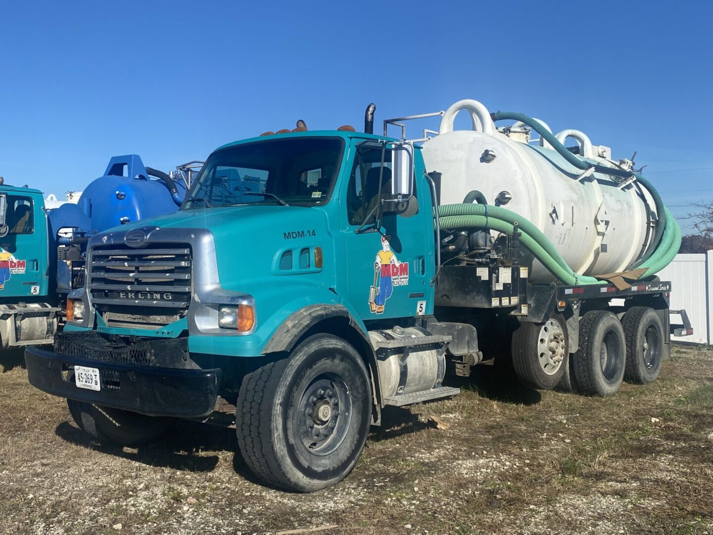 A blue truck with a white and green tank on the back.