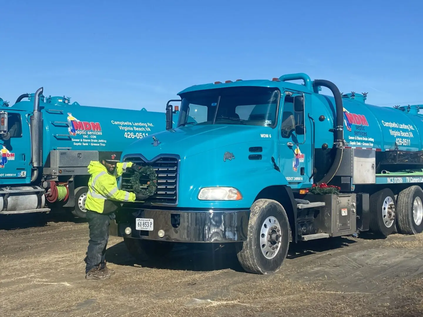 A man standing next to a blue truck.