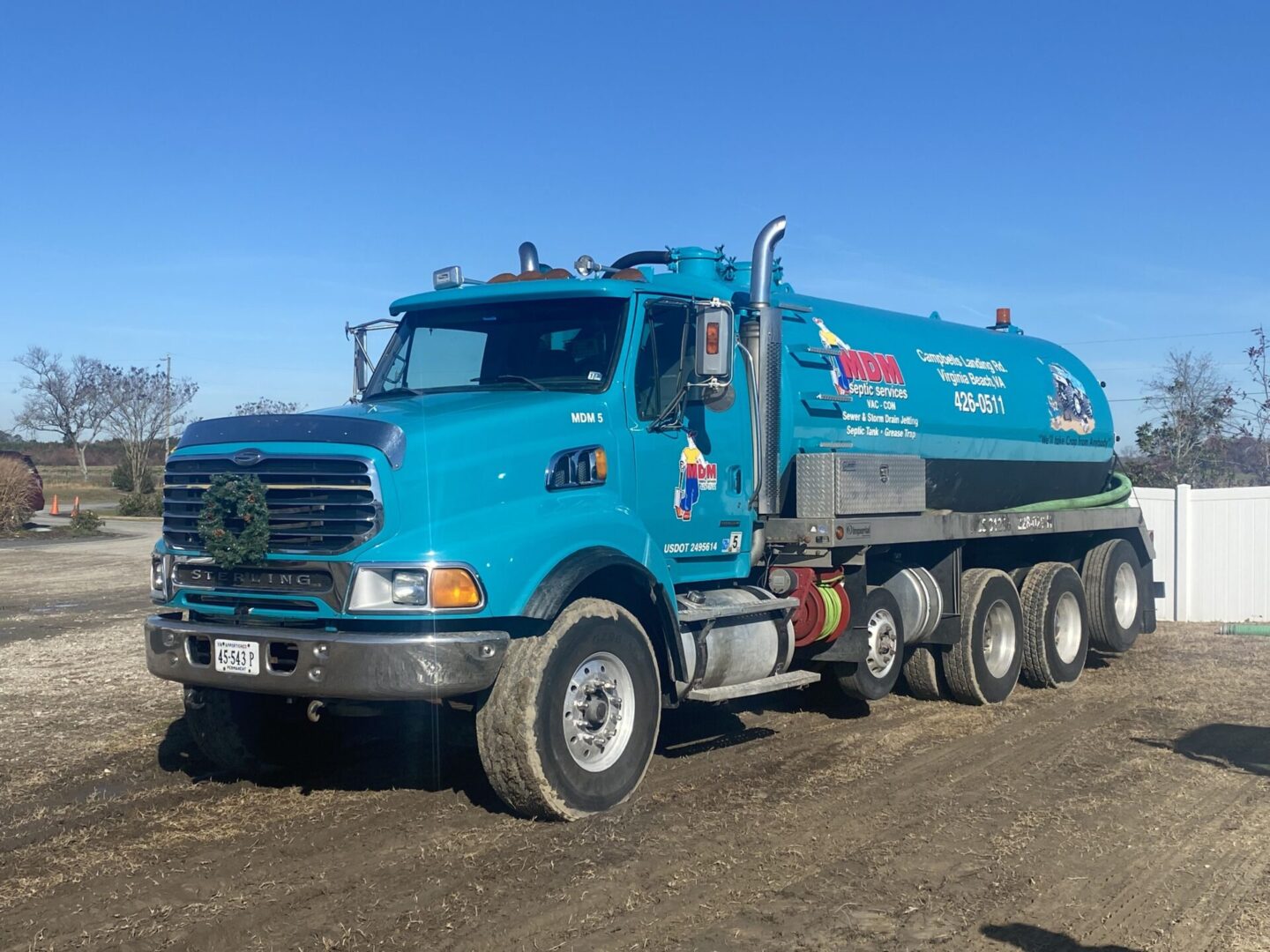 A blue truck is parked on the dirt.