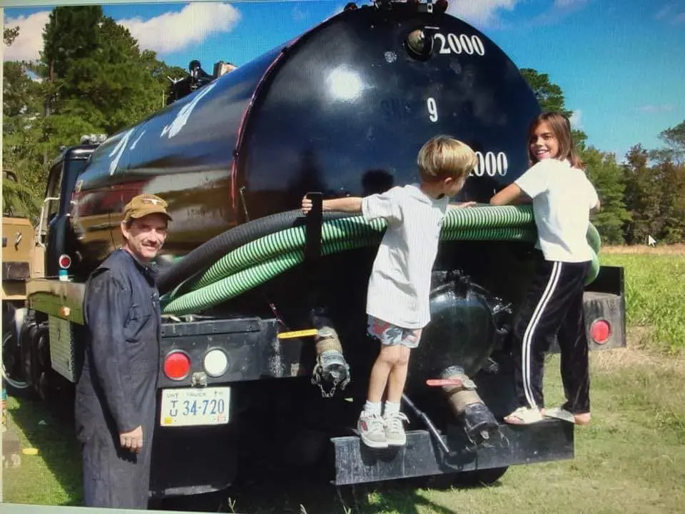 A boy and his mother are standing next to an old train.