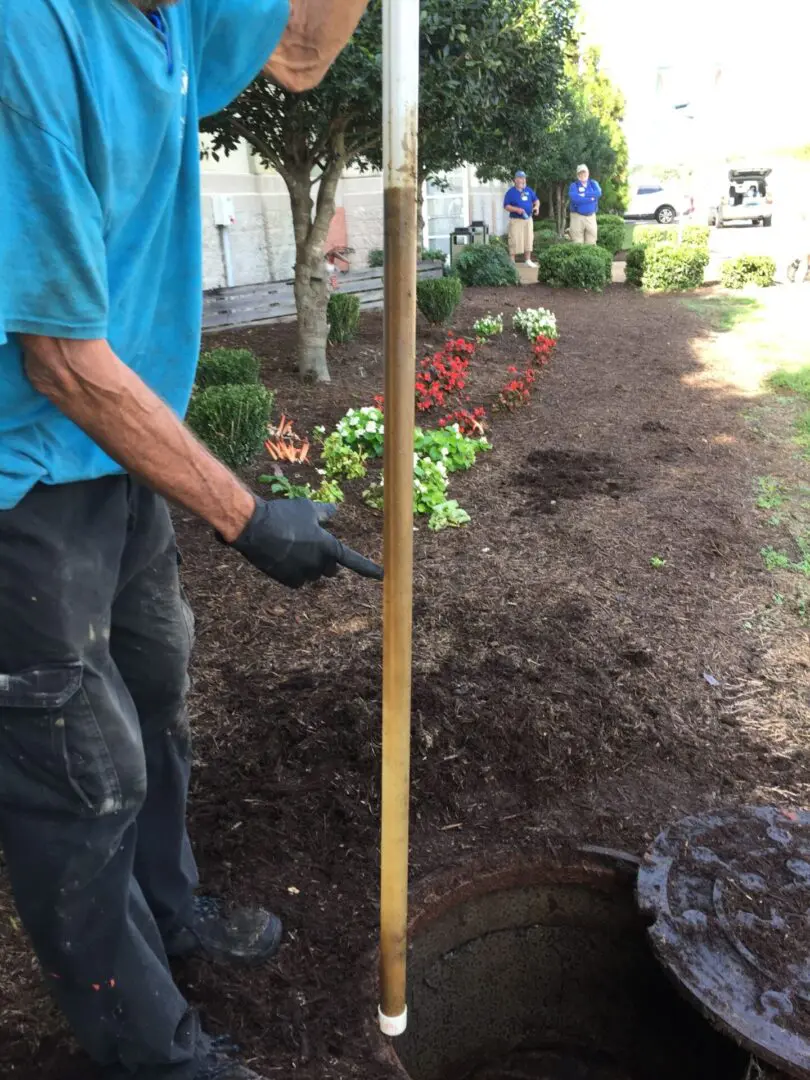 A man in blue shirt holding up a pole.